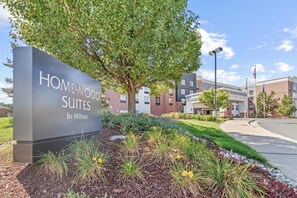 A sign for Homewood Suites by Hilton, surrounded by a landscaped garden with various plants and a large tree. - Homewood Suites by Hilton Denver Tech Center (Englewood)