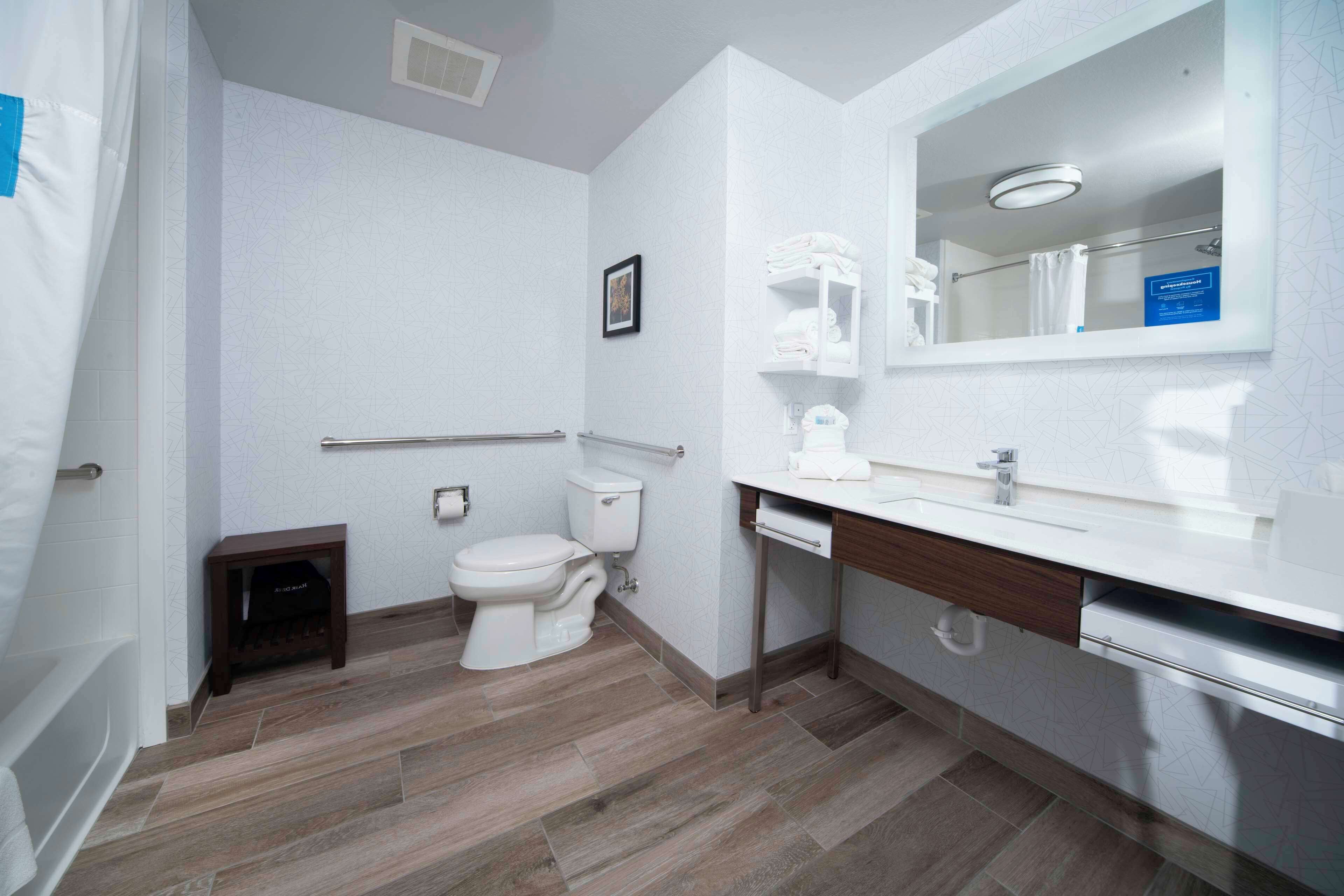 Une salle de bain moderne avec des toilettes, un lavabo et un miroir.