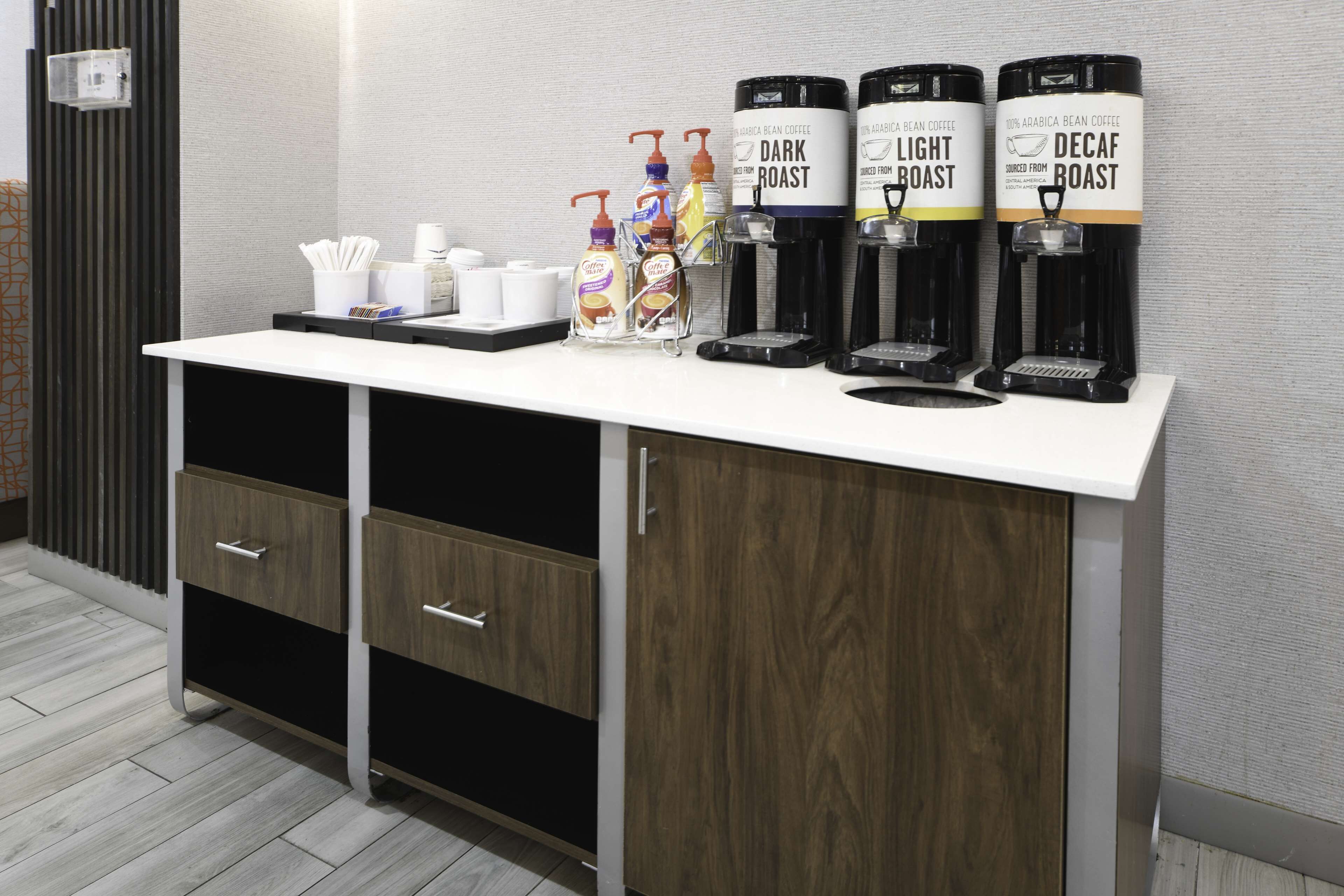 A coffee station with multiple dispensers labeled 'Dark Roast,' 'Light Roast,' and 'Decaf Roast.'