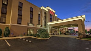 Ein Hampton Inn Hotel mit überdachter Eingangspartie, Parkplatz und einer Ziegel-Fassade.