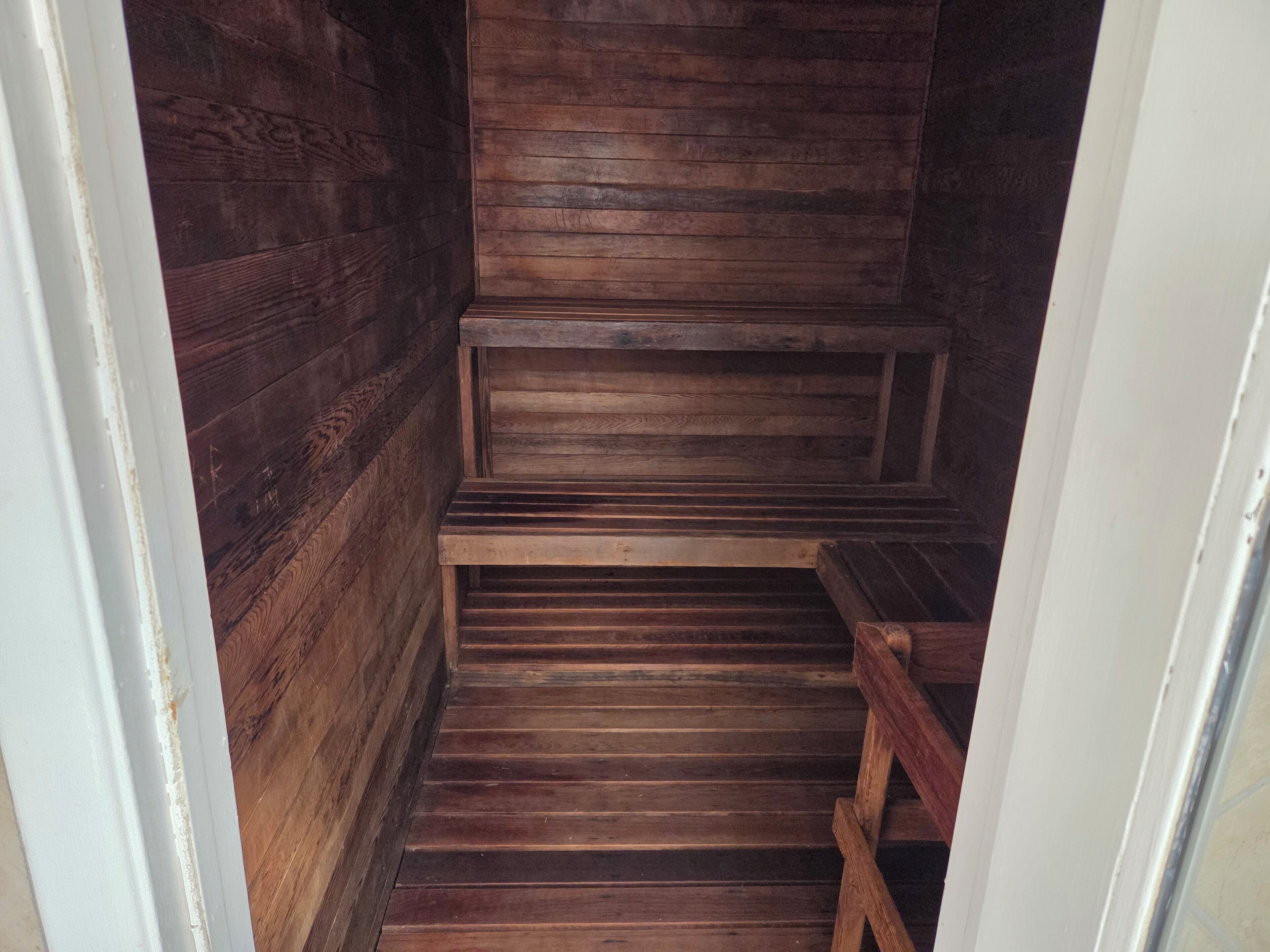 Un sauna en bois avec des bancs, et un banc situé à droite.