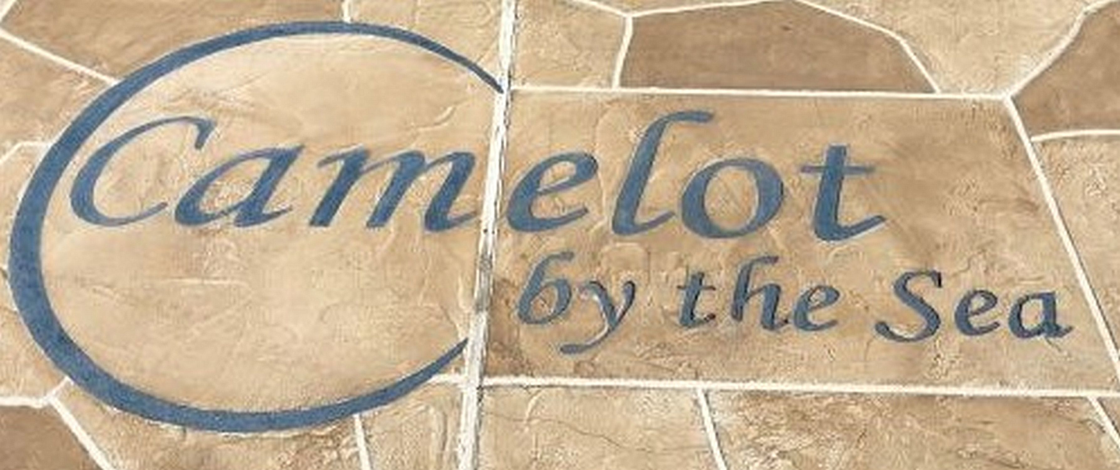Een stenen bord met de tekst 'Camelot by the Sea'.