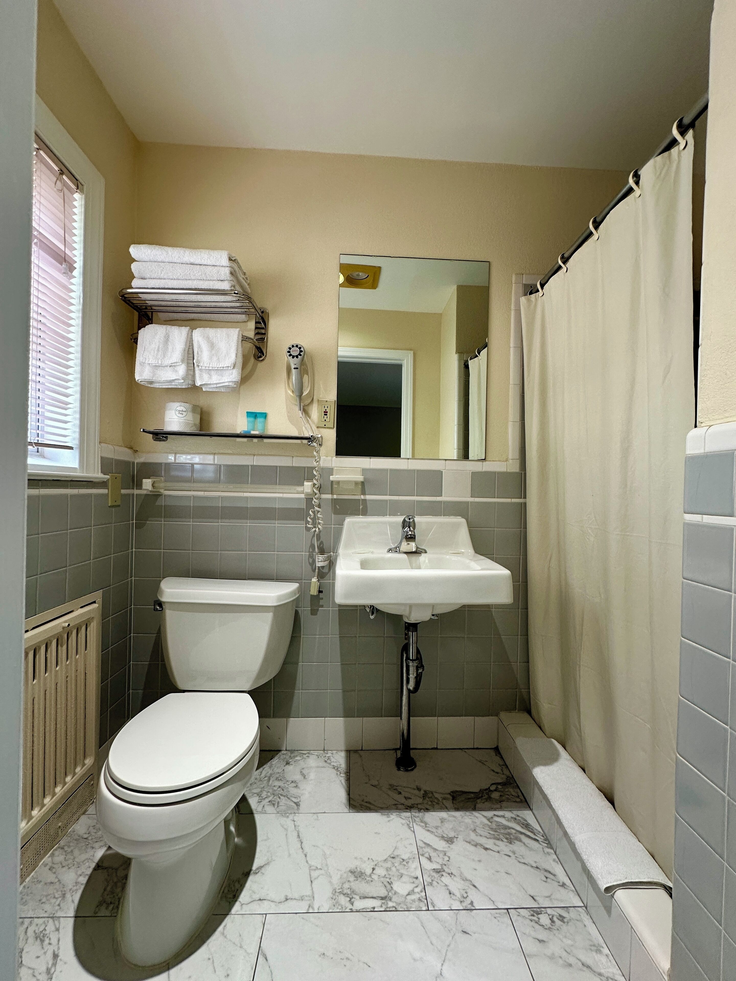 Un baño pequeño con inodoro, lavamanos y zona de ducha.
