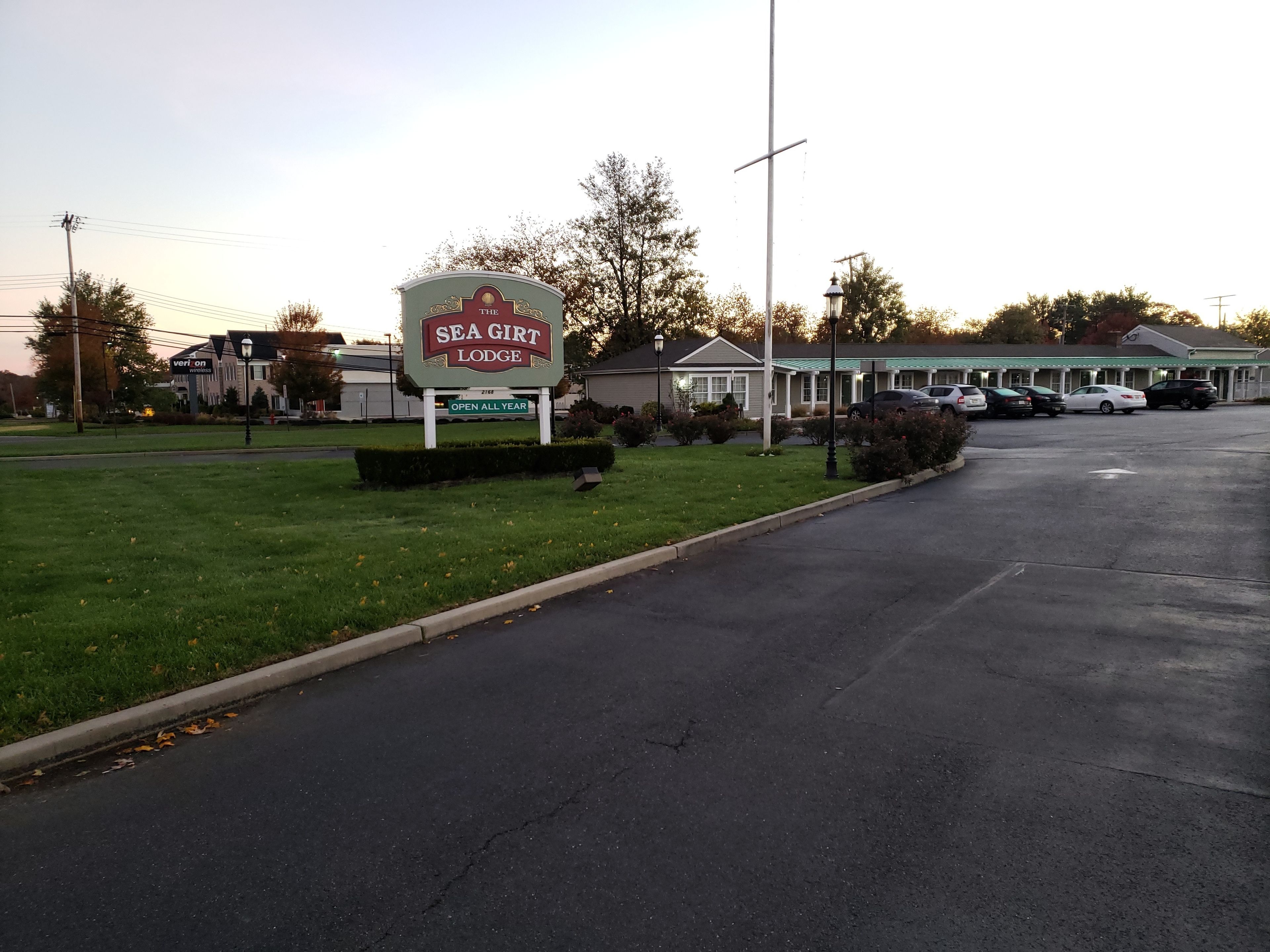 Señal de Sea Girt Lodge, césped verde y aparcamiento.