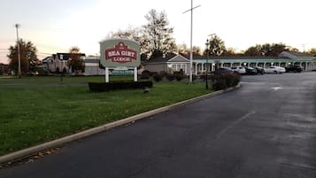 Señal de Sea Girt Lodge, césped verde y aparcamiento.