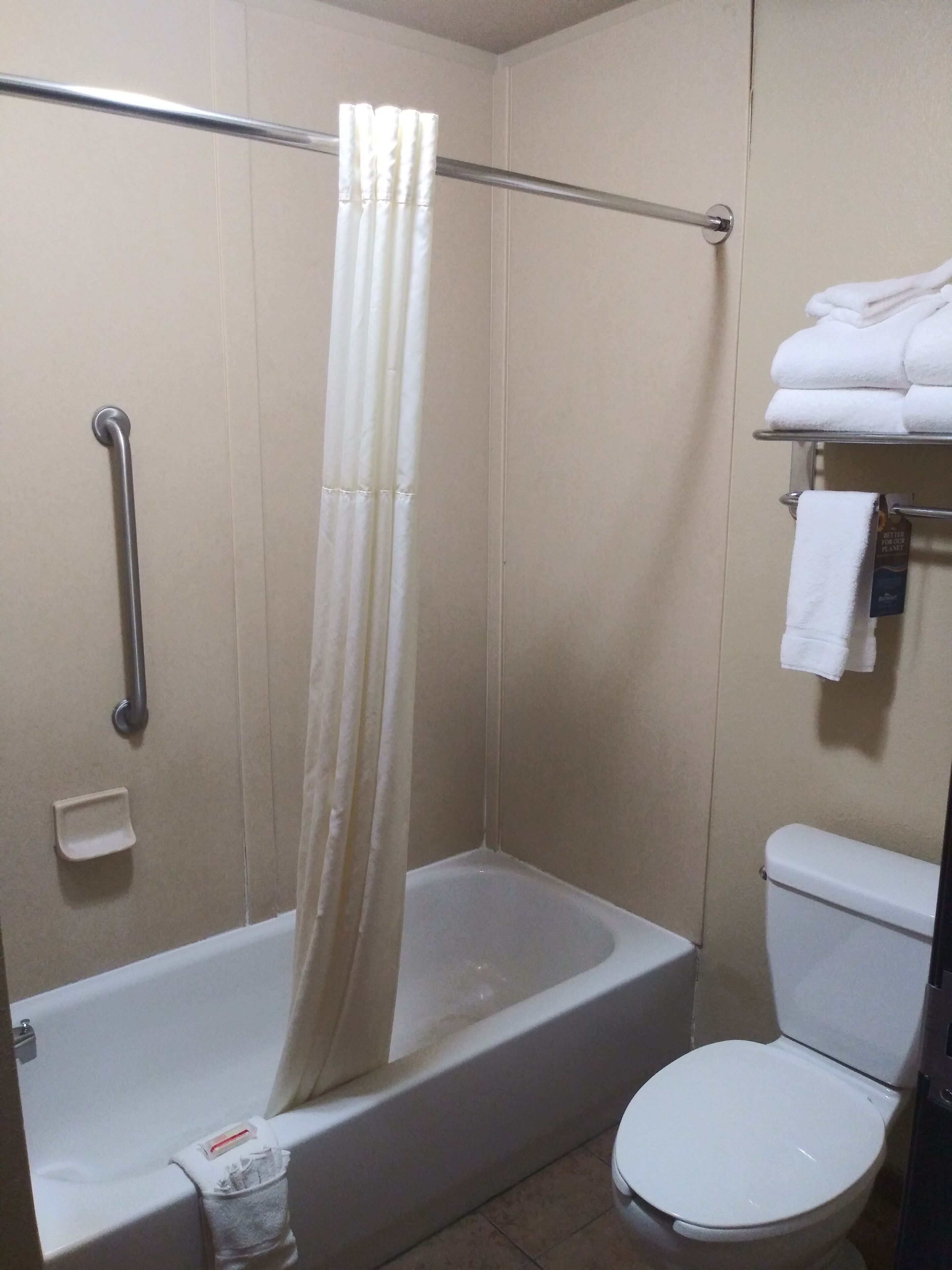 Un baño con bañera, inodoro y cortina de ducha.