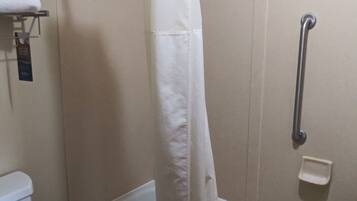 A bathroom with a bathtub, toilet, and a shower curtain.