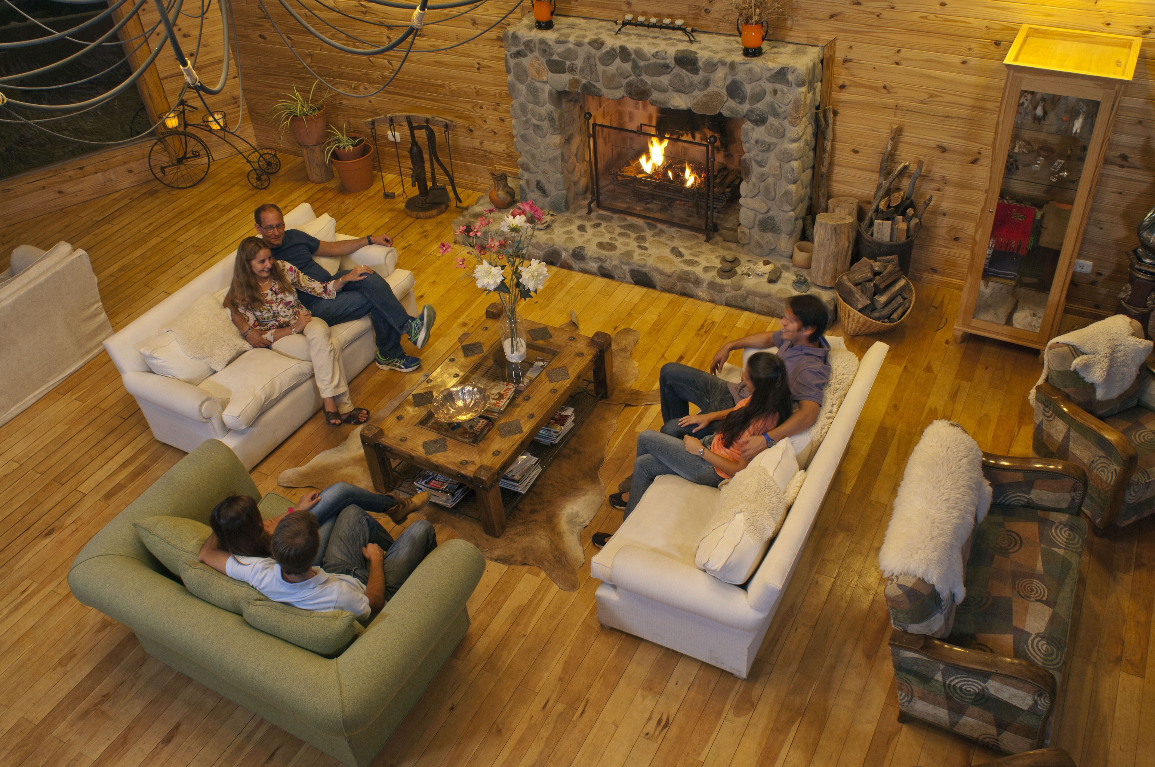 A cozy cabin interior with a stone fireplace, wooden furniture, and a rustic decor.
