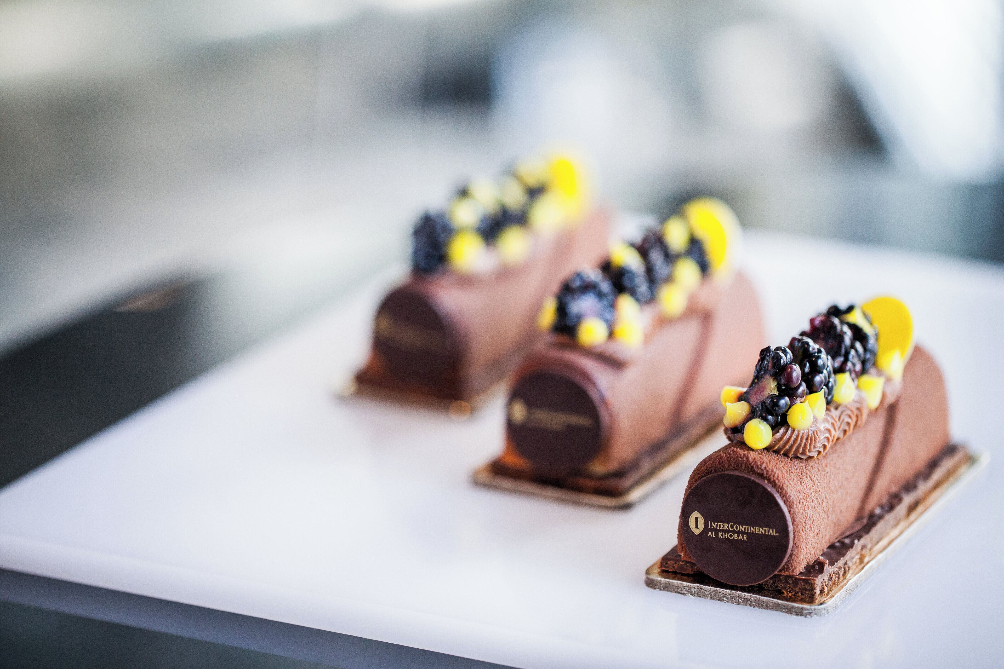 Drie chocoladedesserts op een wit bord.