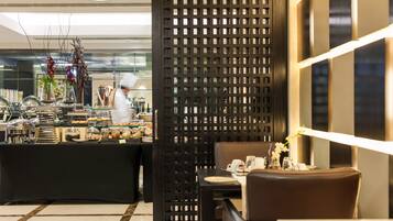 A restaurant with a buffet area, a seating area with tables and chairs, and a decorative partition.