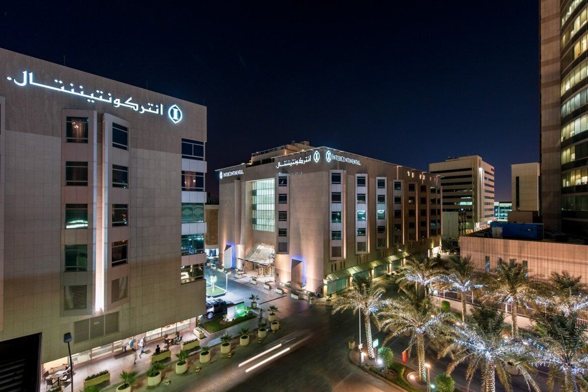 A hotel with a modern facade, multiple floors, and a well-lit entrance area.