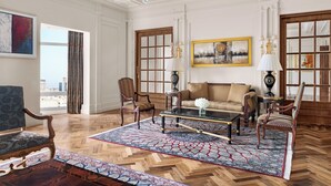 Une pièce spacieuse avec une grande fenêtre, un canapé, une table basse et un tapis à motifs.