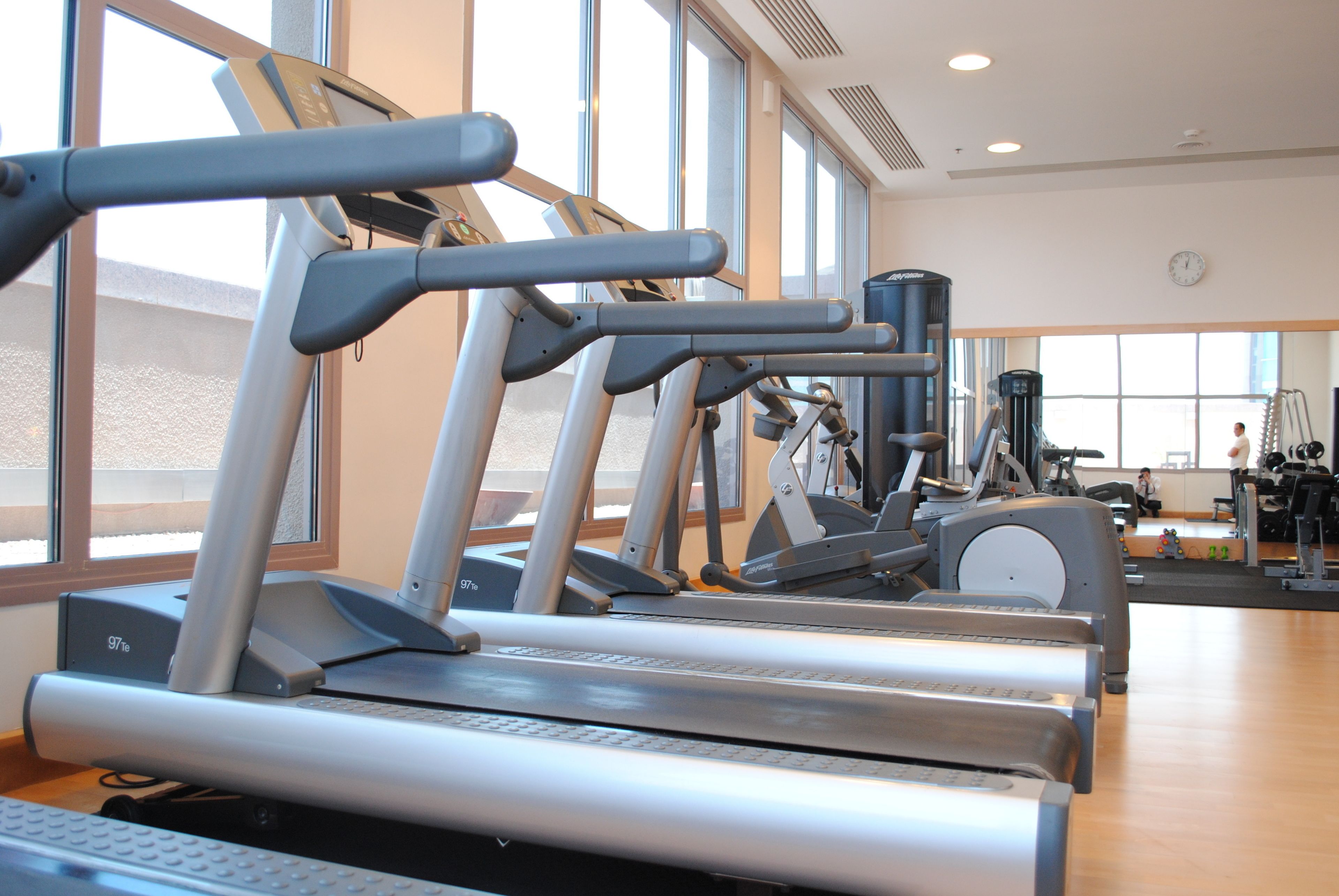 A gym with multiple treadmills, exercise bikes, and other fitness equipment.