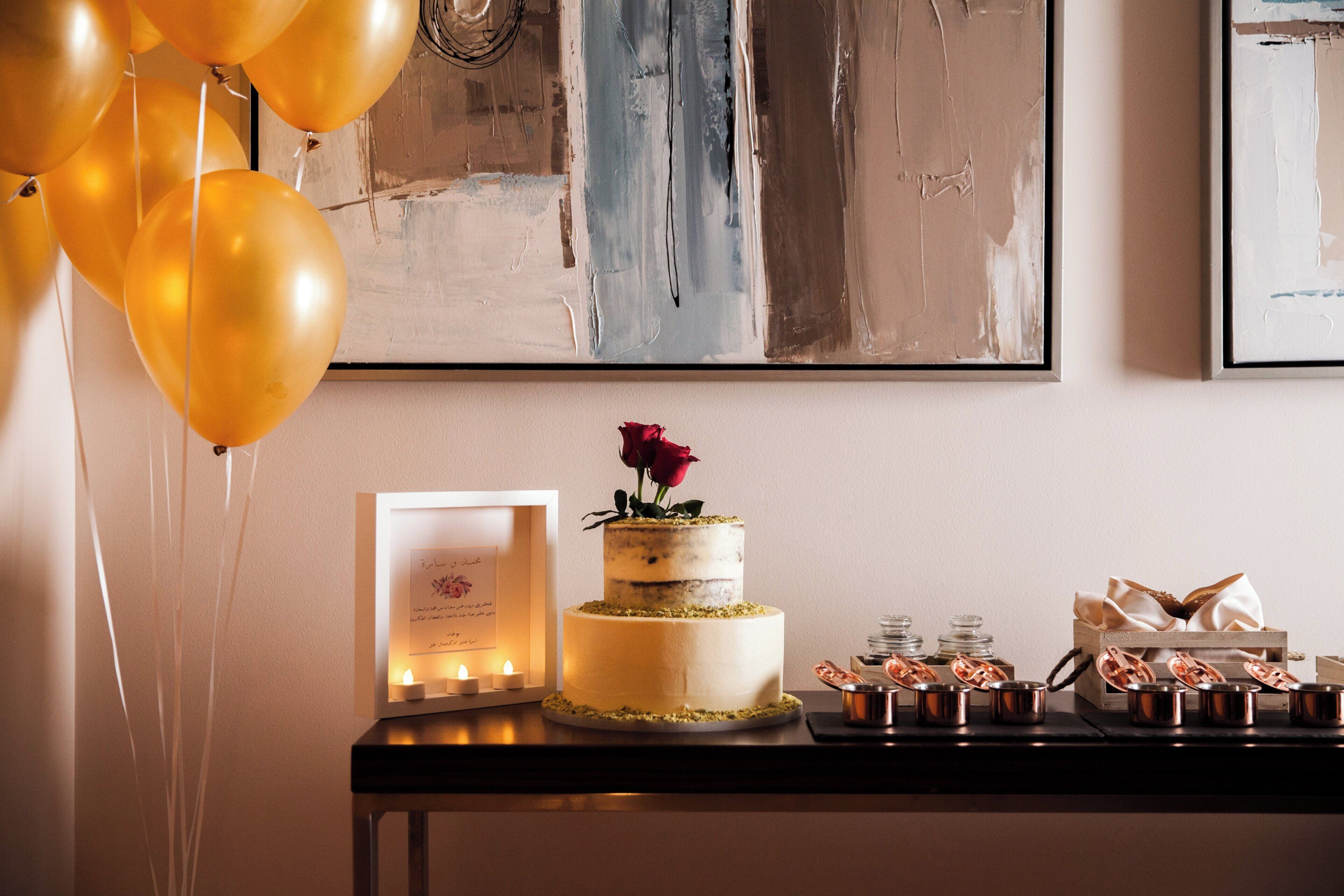 A dessert table with a cake, candles, and a framed note.