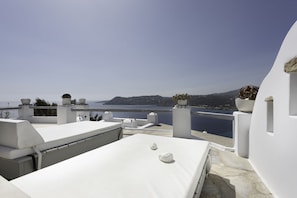 Relax on the rooftop terrace with a serene view of the sea and distant hills.