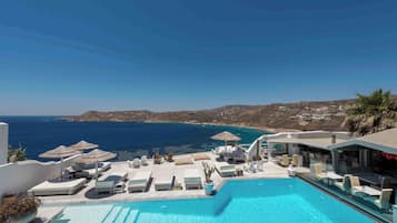 Relax by the ocean-view pool surrounded by lounge chairs and umbrellas.