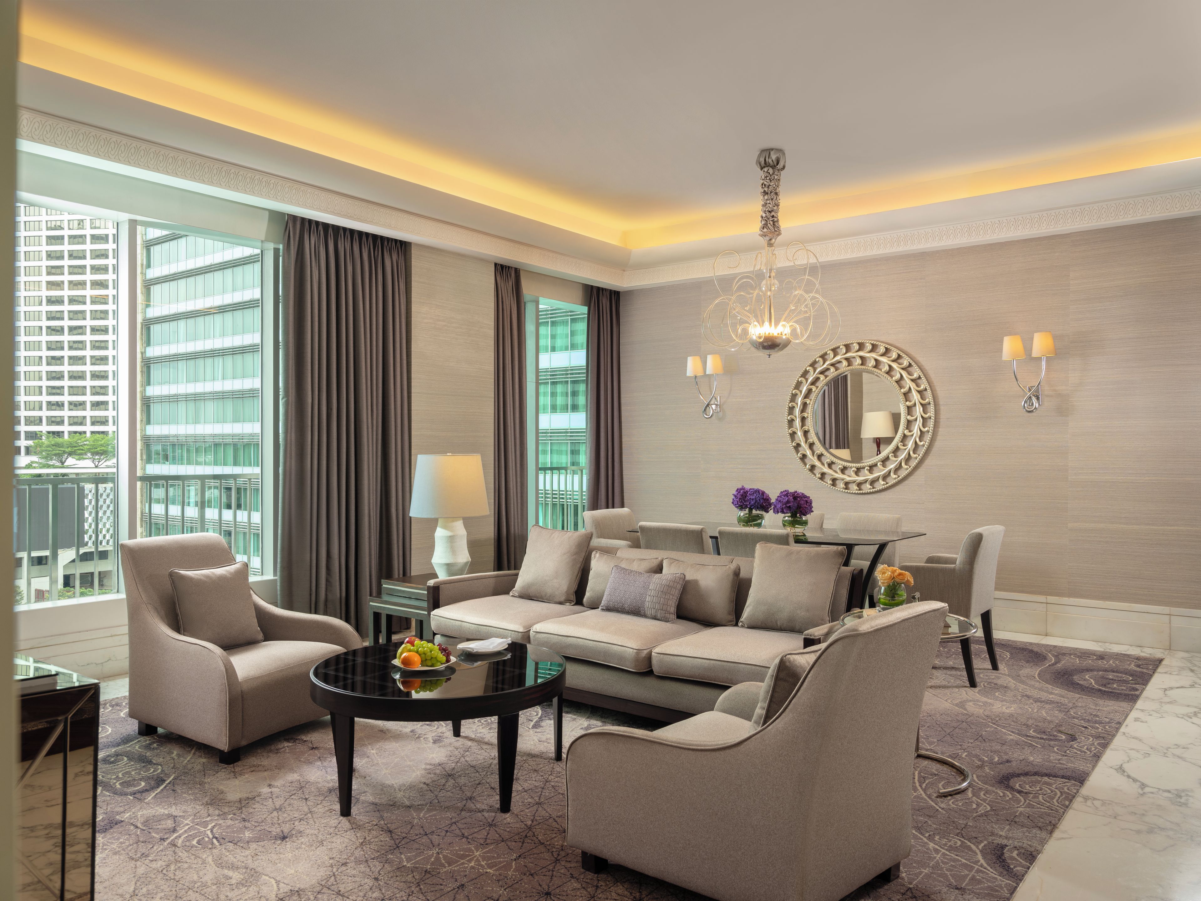 A modern hotel room with a sofa set, a dining table, and a large window with curtains.