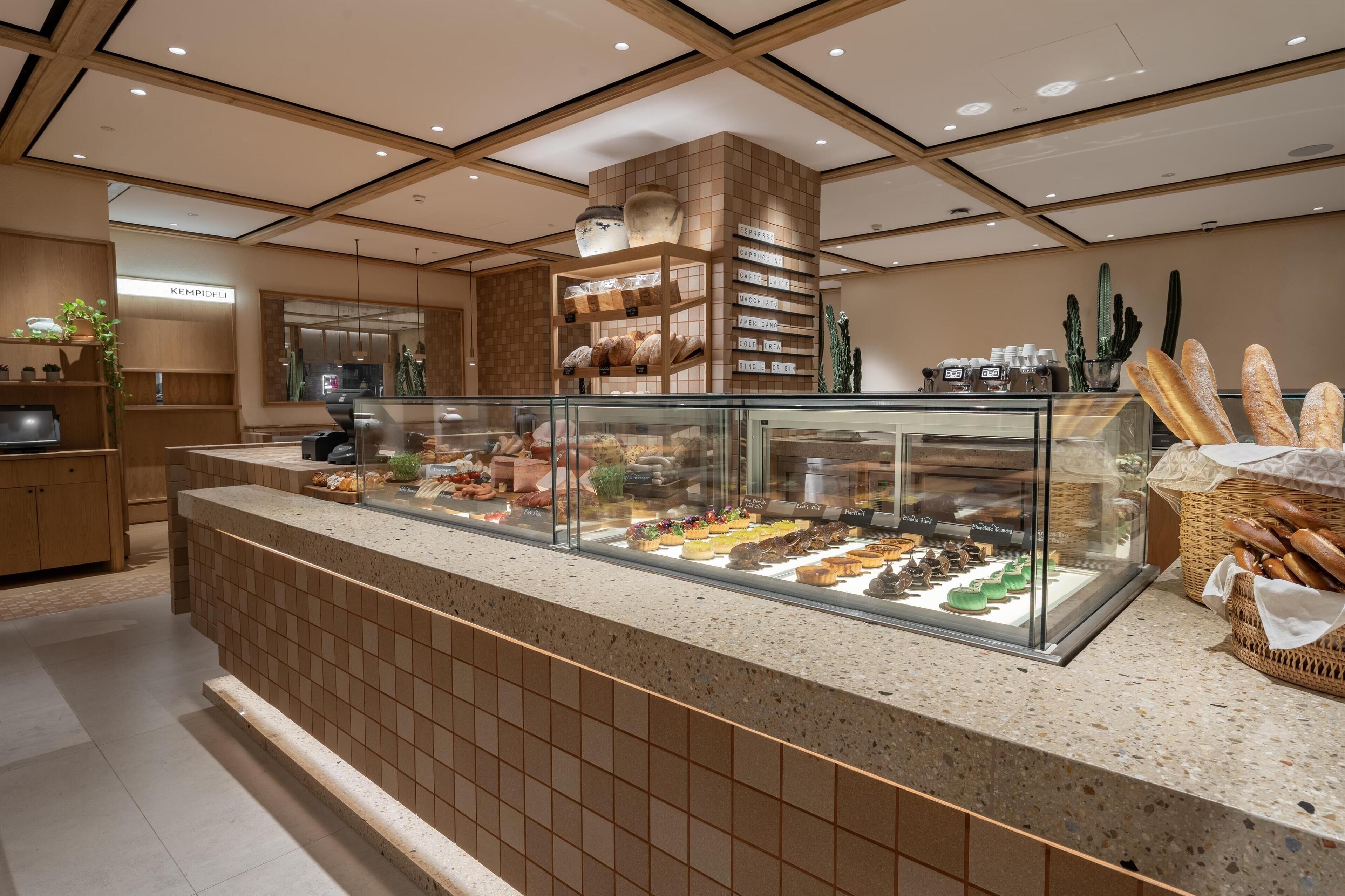 Un comptoir de boulangerie où sont présentés divers produits de boulangerie et pâtisseries dans une vitrine.