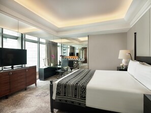 A hotel room with a large bed, a television, a desk, and a mirror. - Hotel Indonesia Kempinski Jakarta (Jakarta)