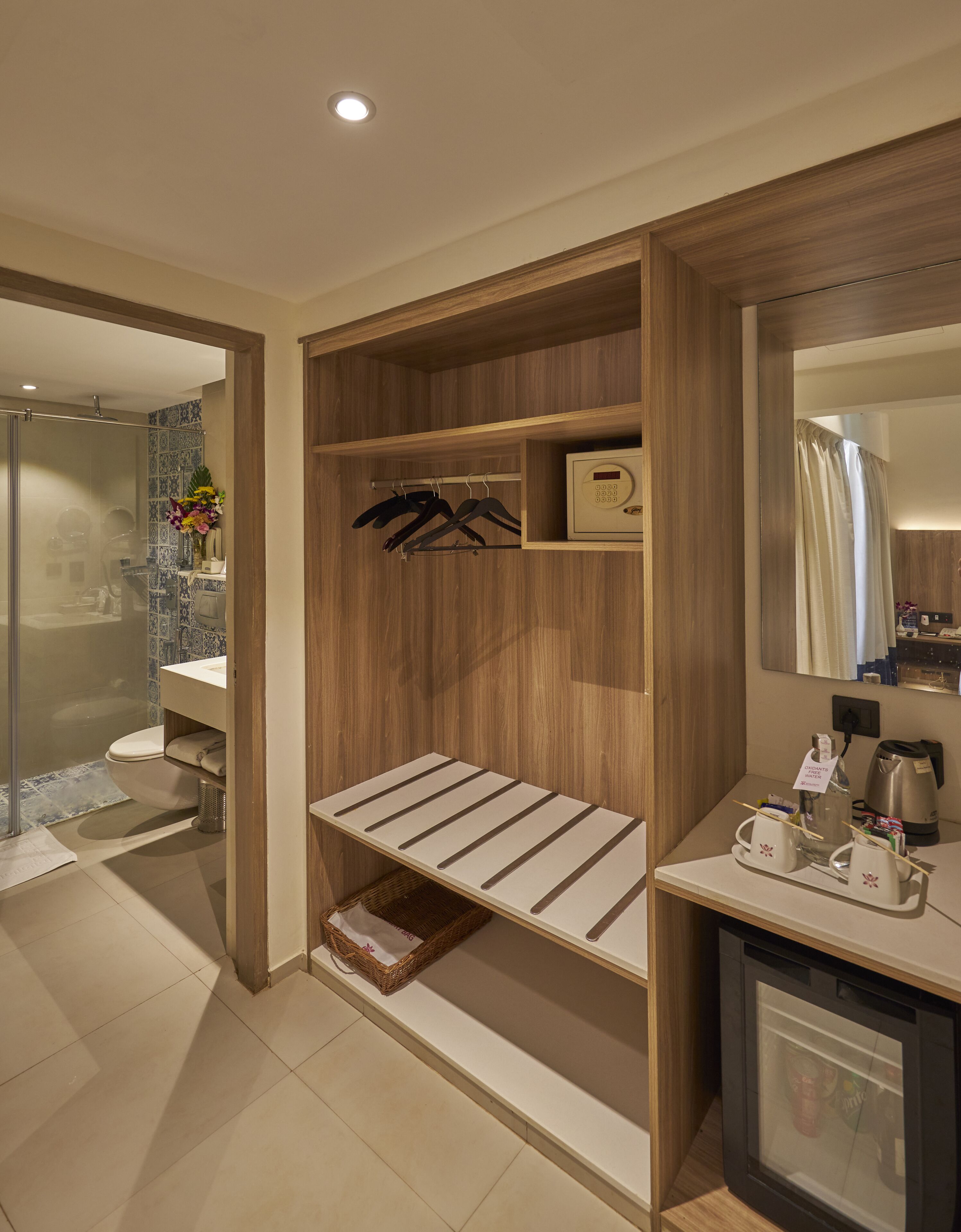 A modern bathroom with a wooden vanity, a shower area, and a coffee station.