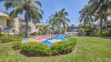 Guests can enjoy a vibrant play area surrounded by lush greenery and palm trees.