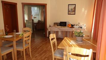Un comedor con muebles de madera, una mesa con mantel blanco y una planta en maceta.