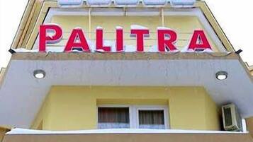A hotel sign with the name "HOTEL PALITRA" and a sign below it that reads "CEMEEH XOTEA".
