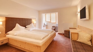 A hotel room with a large bed, a desk, a chair, and a television. - Hotel Nova (Gaschurn)