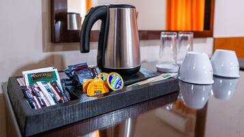 Una bandeja con tetera, tazas de café y aperitivos en la encimera de un hotel.