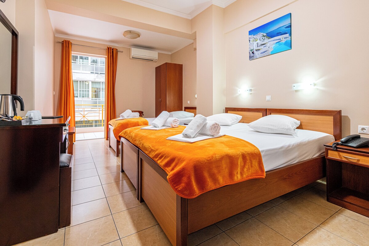 A hotel room with a bed, two bedside tables, a desk, and a chair.