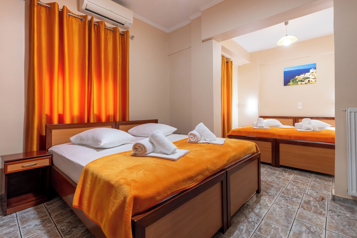 A hotel room with two beds, a wooden headboard, a nightstand, and a painting on the wall.
