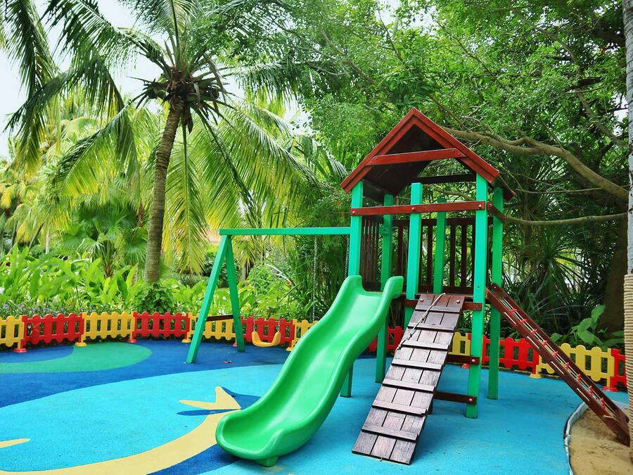 A playground with a slide, climbing structures, and a small shelter.