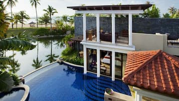 A resort with a swimming pool, a covered outdoor area, and a view of the beach.