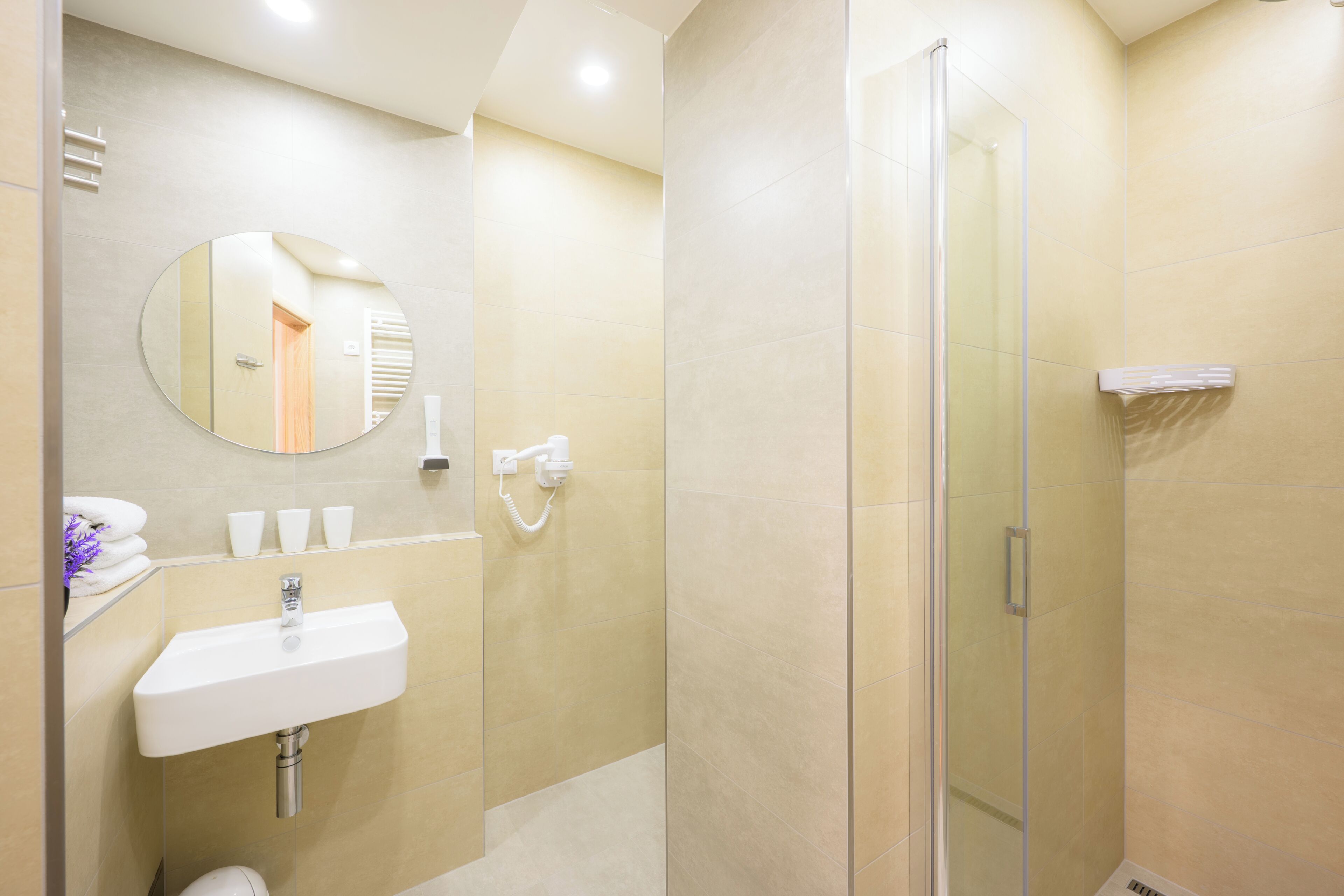 Un baño moderno con lavamanos, espejo y cabina de ducha de vidrio.
