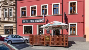 A red building with a sign that reads "SALON ROUDN". - Hotel Palace (Plzen)