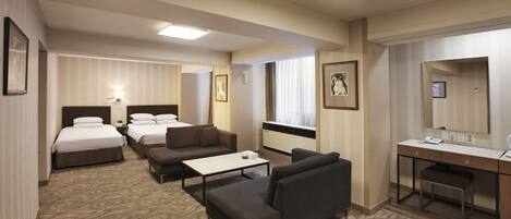 Une chambre d’hôtel avec deux lits, un bureau, une chaise, un canapé et une petite table.