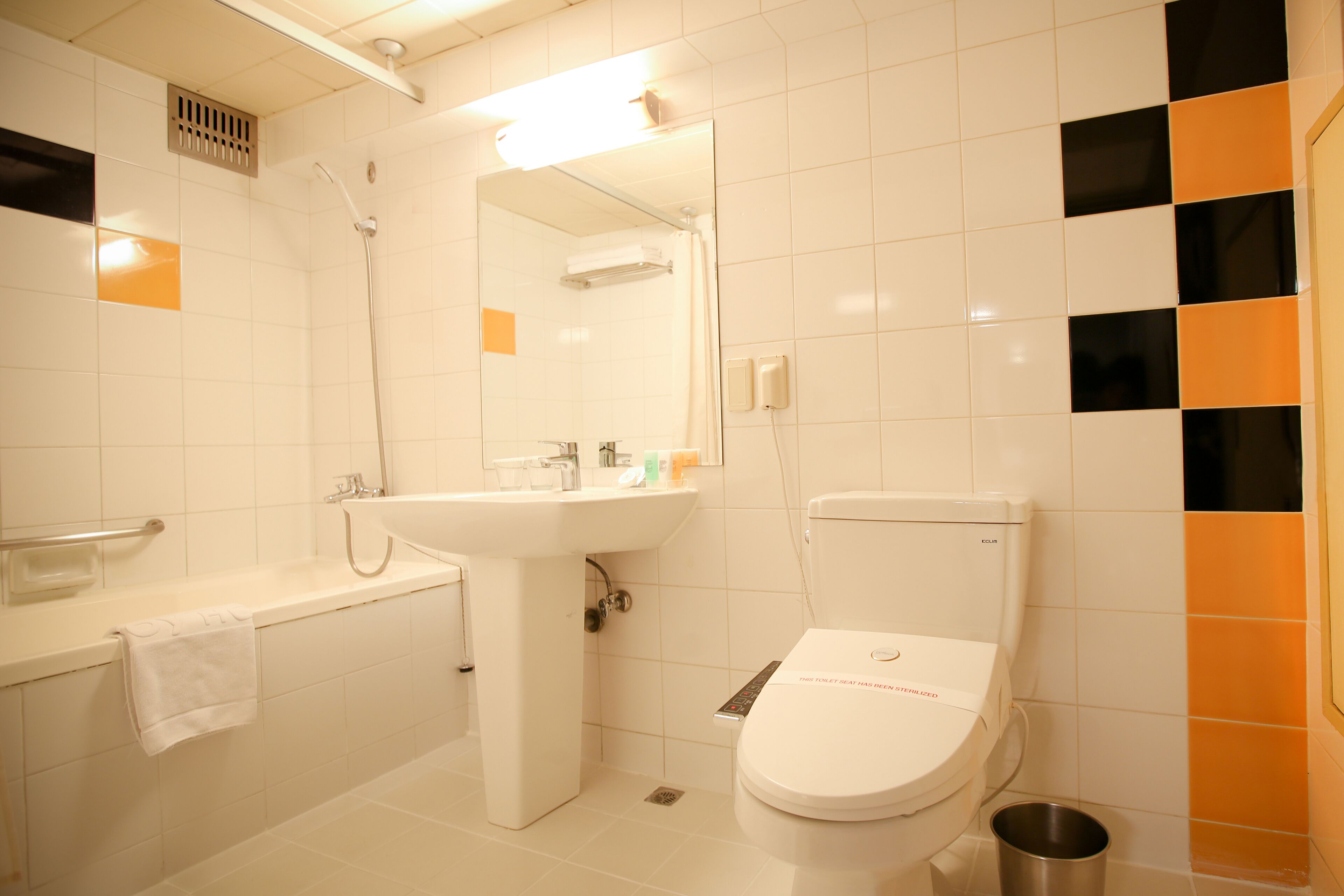 A bathroom with a toilet, sink, and shower.