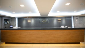 A reception desk with a sign that reads "SAVOY HOTEL" and a phone on the counter. - Savoy Hotel (Seoul)
