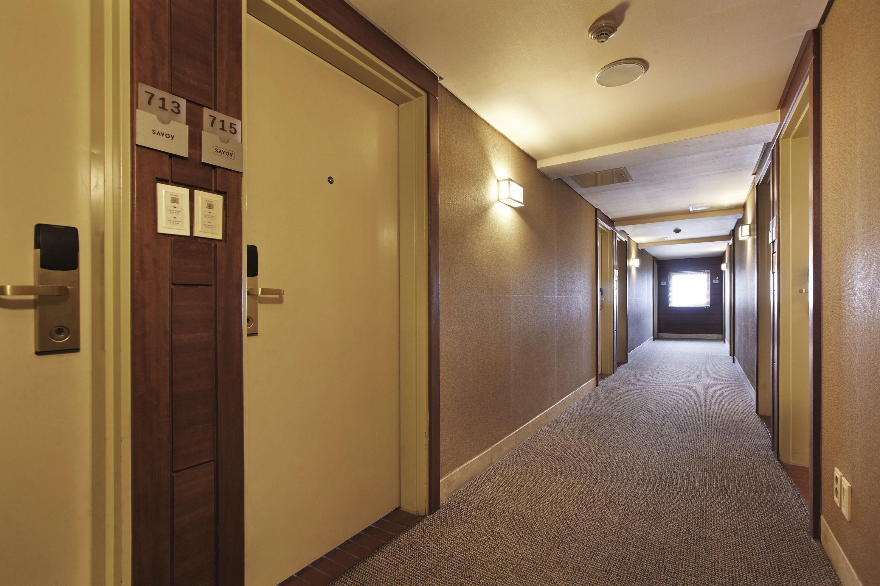 A hotel hallway with doors numbered 713 and 715, both labeled 'Savoy'.