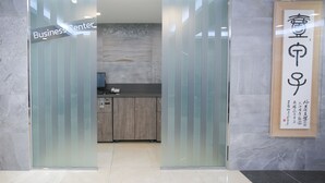 A business center entrance with a sign, a reception desk, and a framed calligraphy piece on the wall. - Savoy Hotel (Seoul)