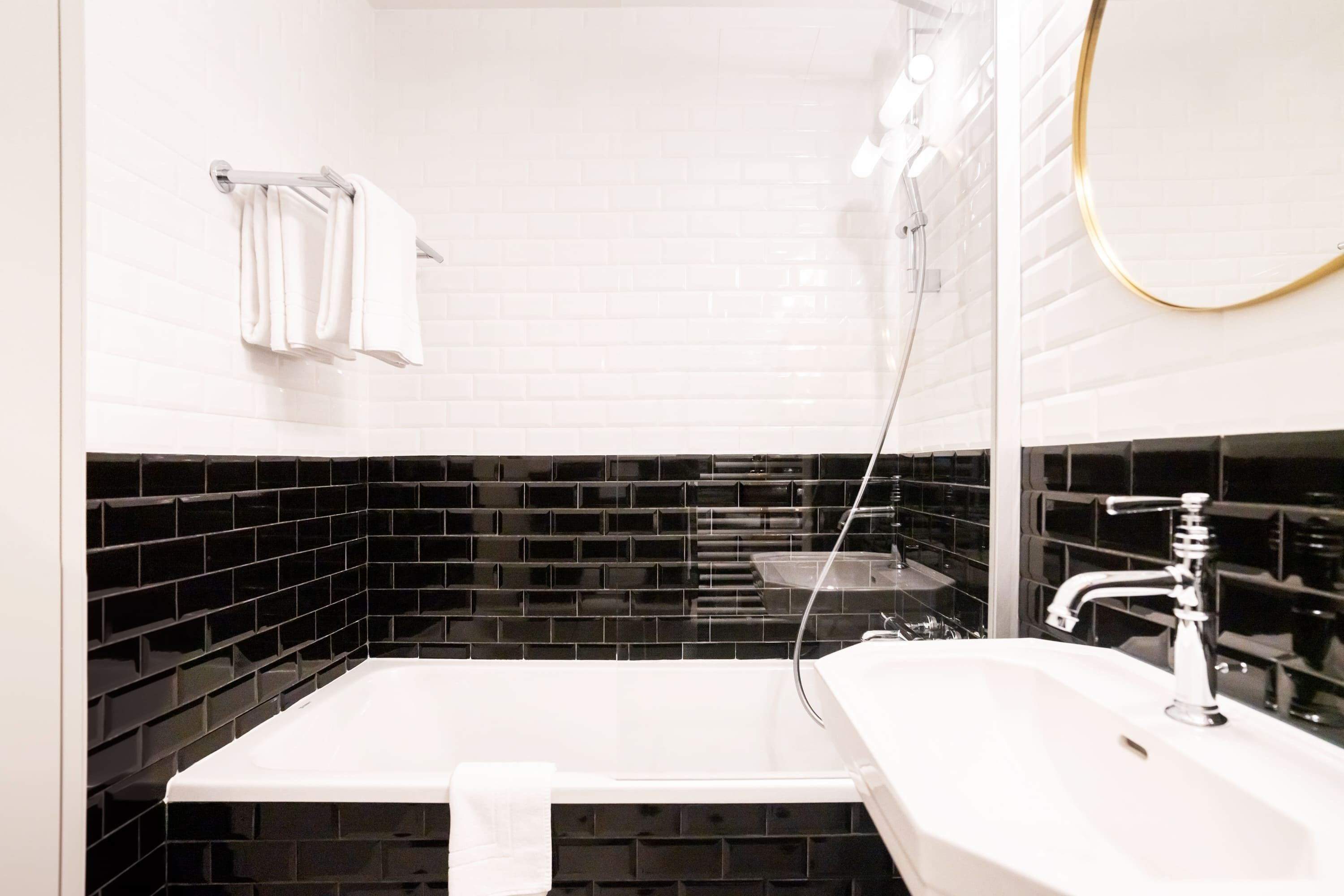 A modern bathroom with a white bathtub, a sink, and a mirror.