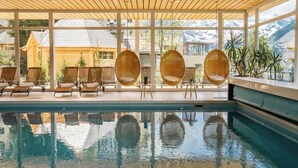 Un espace piscine agrémenté de fauteuils en osier et offrant une vue sur les montagnes.