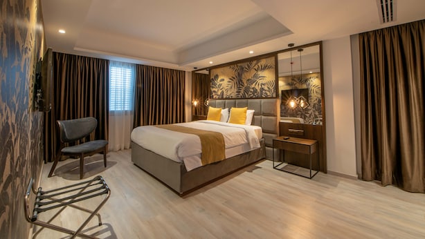 Une chambre d’hôtel moderne, dotée d’un grand lit, d’un bureau et d’une chaise.