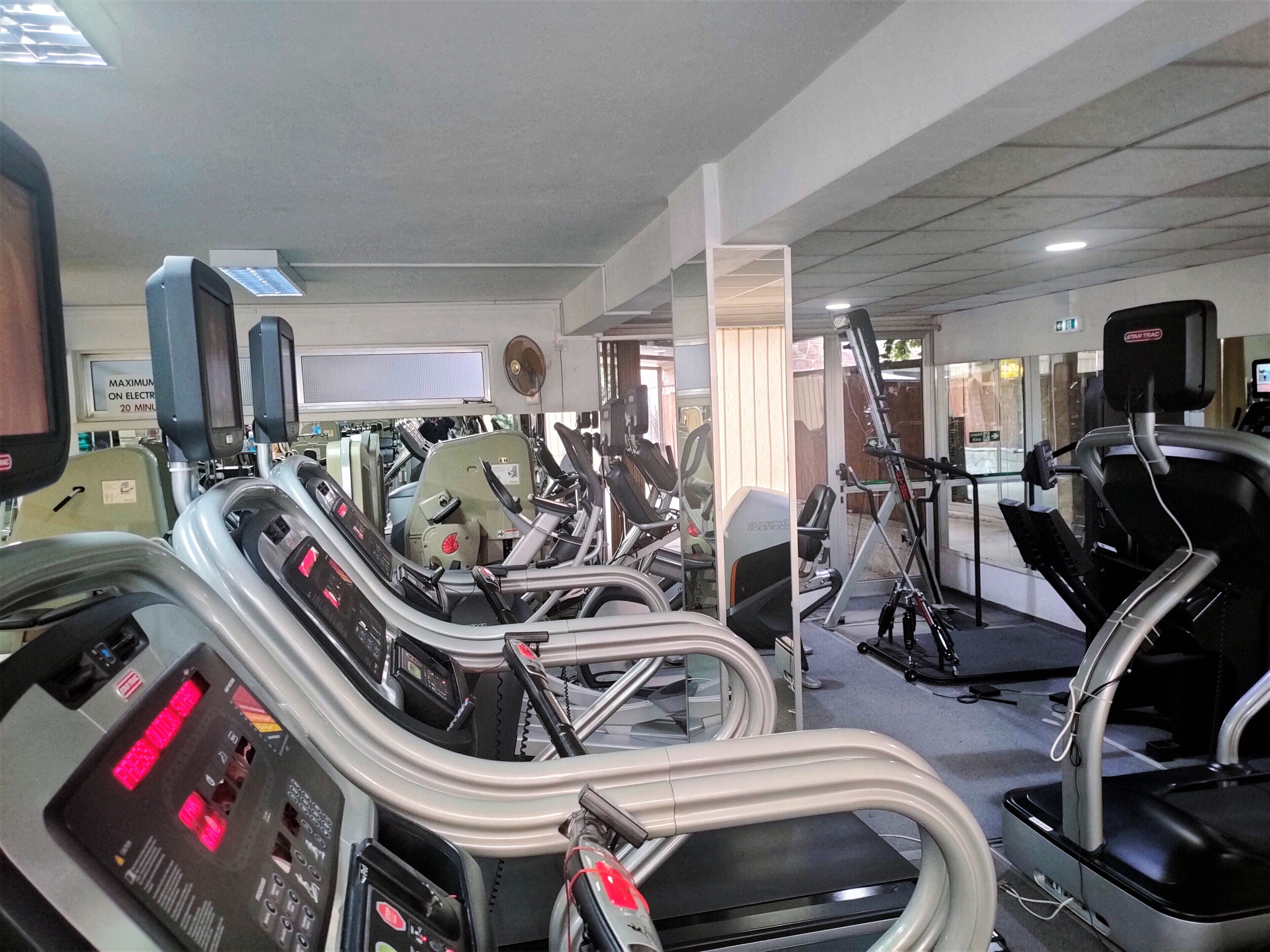 A gym with various exercise machines, including treadmills and elliptical trainers.