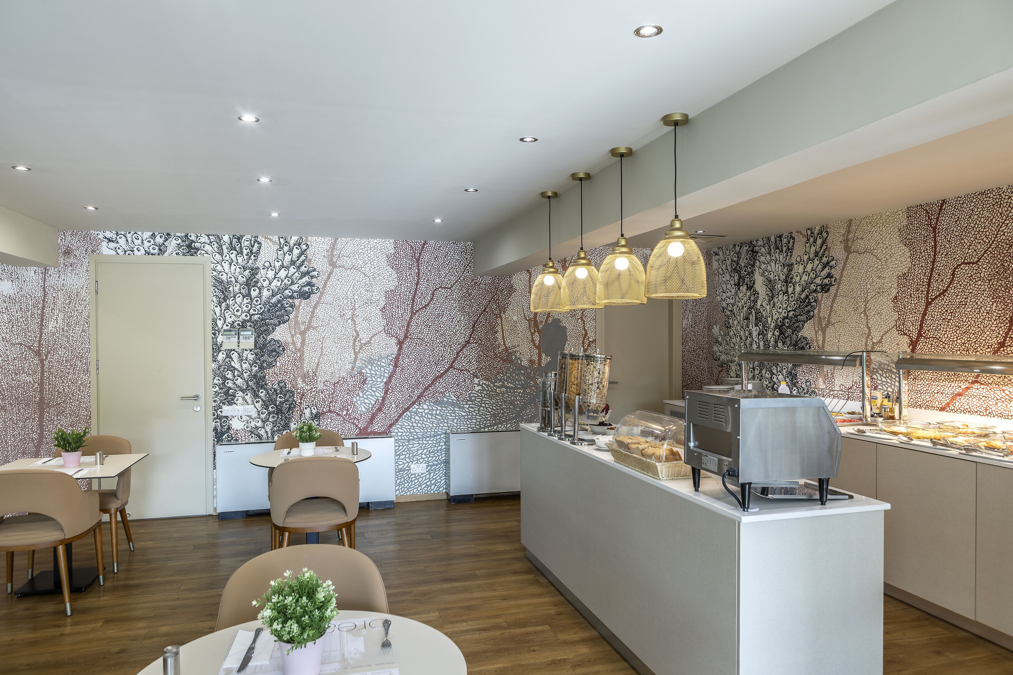 A modern cafe with a central counter, seating area, and decorative wall art.