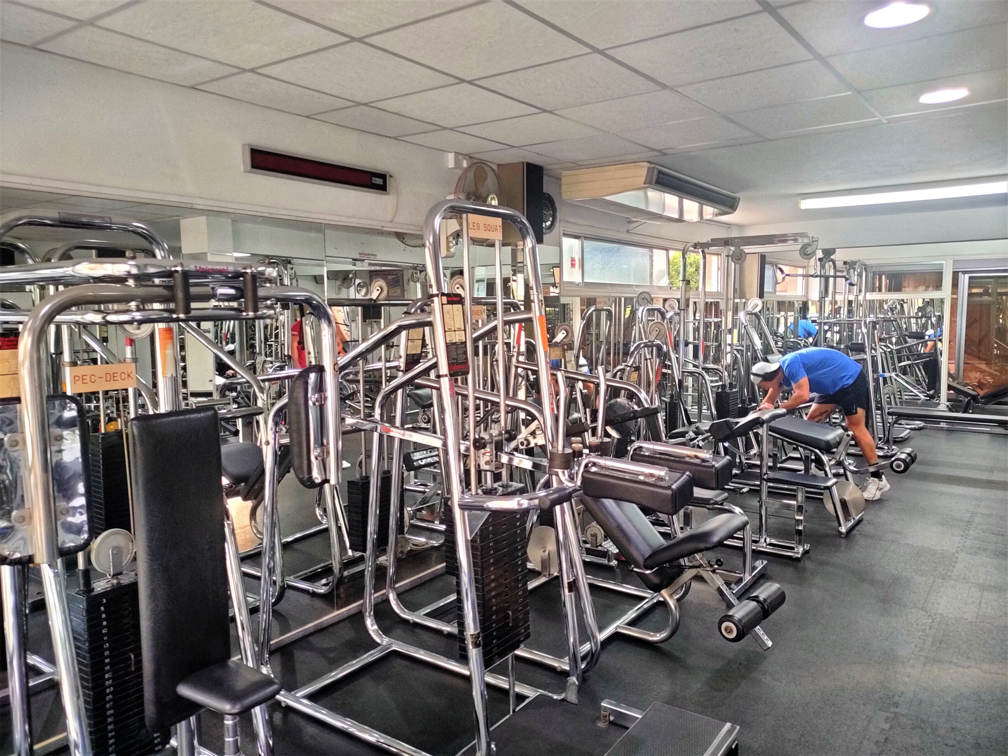 Ein Fitnessstudio mit verschiedenen Trainingsgeräten und Ausstattungsstücken.