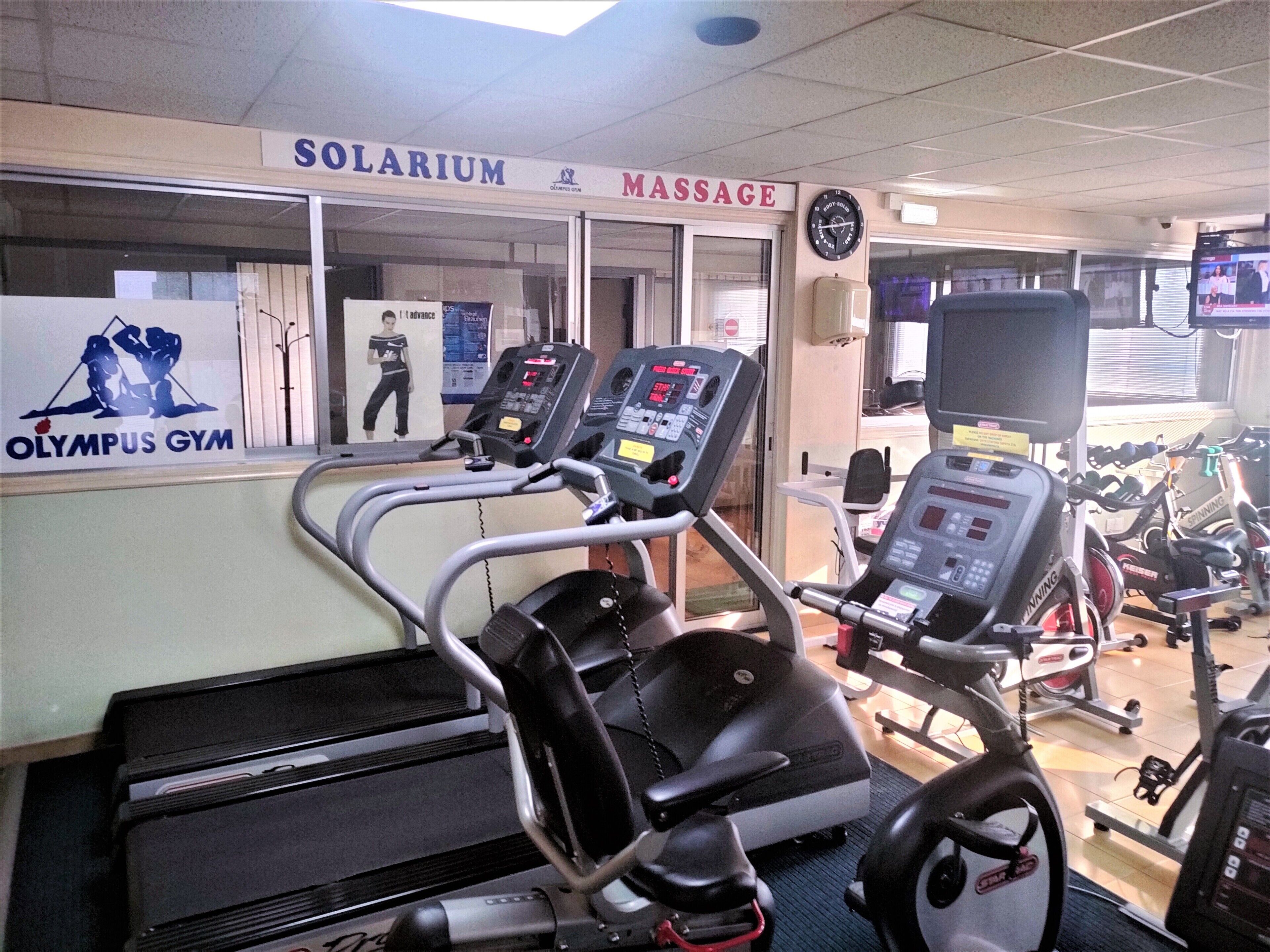 A gym with treadmills, stationary bikes, and a massage area.