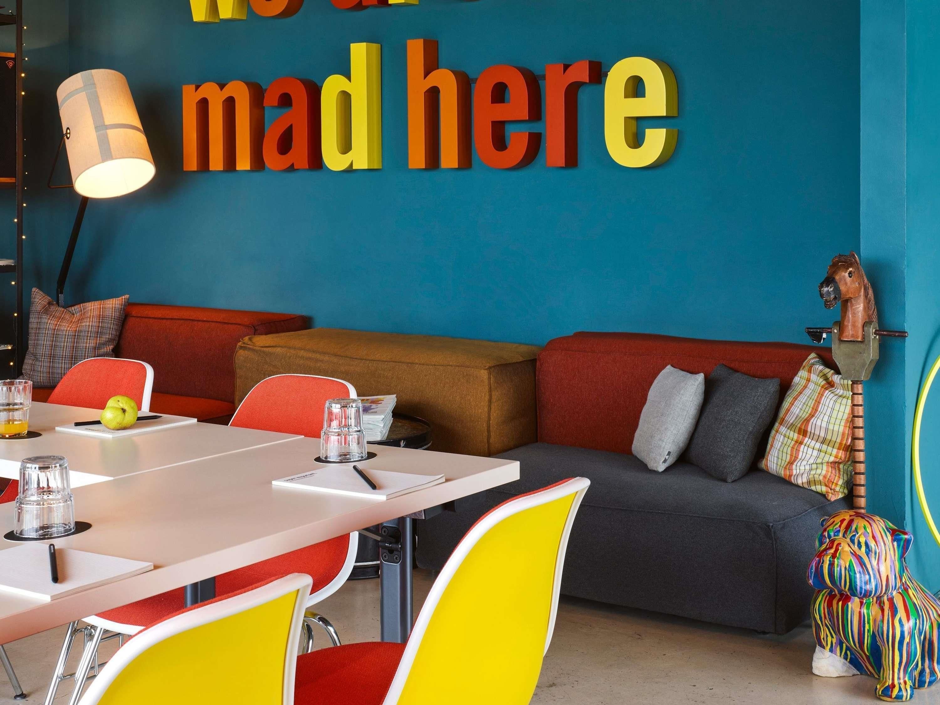 Um interior moderno com um sofá, cadeiras, uma mesa e uma parede com texto.