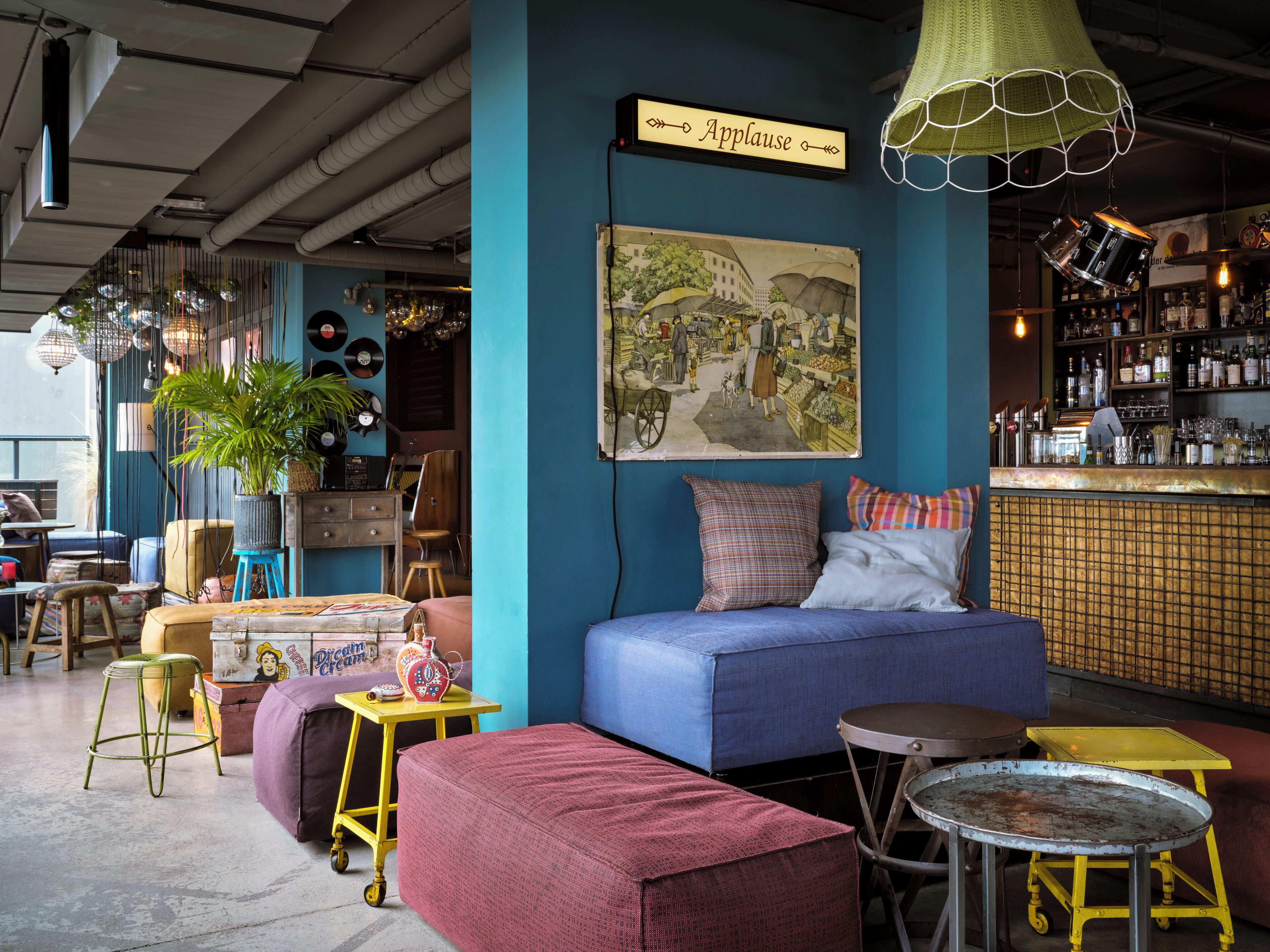 Um interior acolhedor com um sofá azul, um espaço de bar e um quadro antigo na parede.