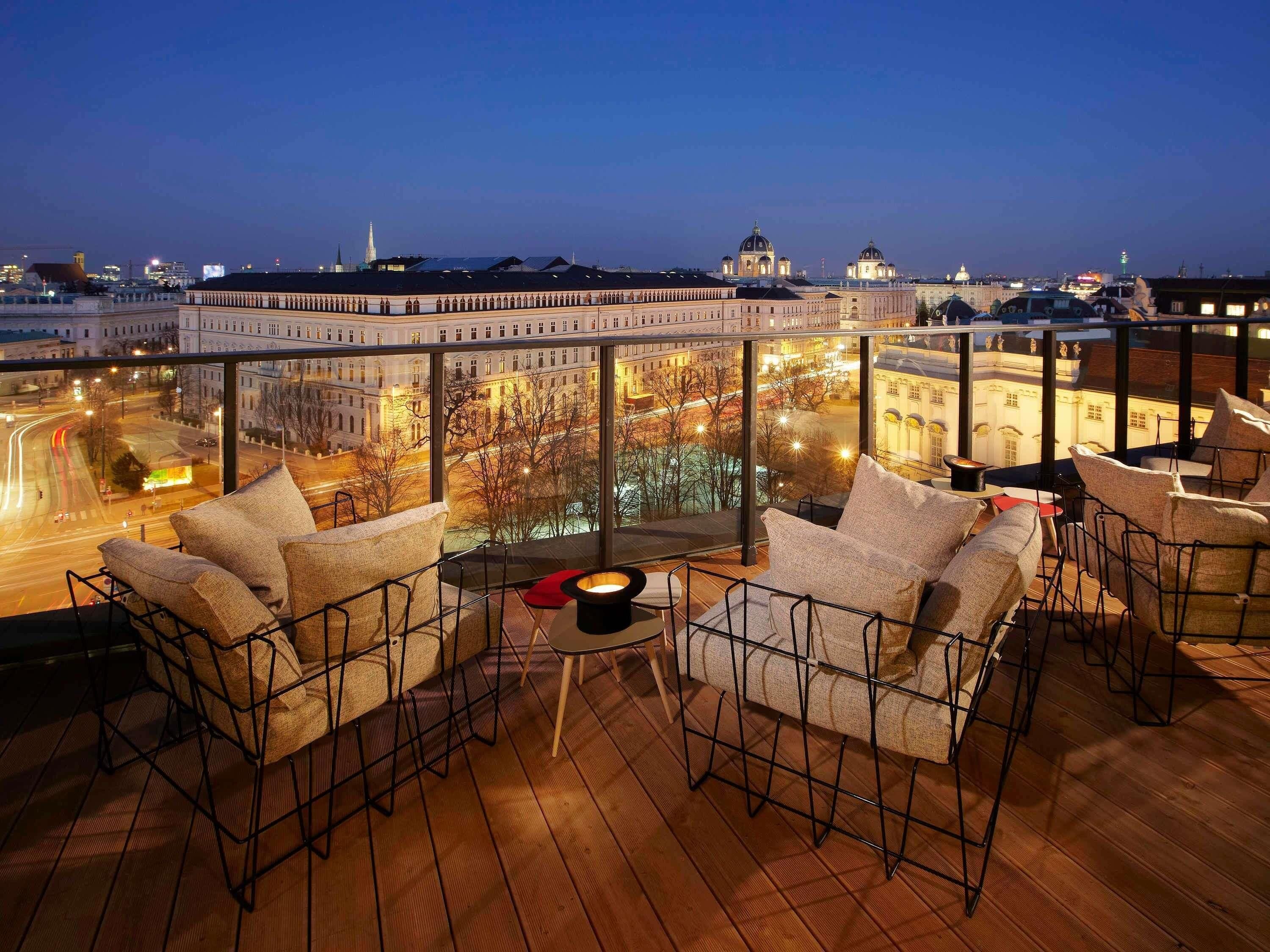 Terraza en la azotea con mobiliario y vista a edificios de la ciudad.